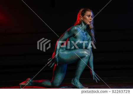 Gorgeous naked brunette posing painted in turquoise sequins. 82263729