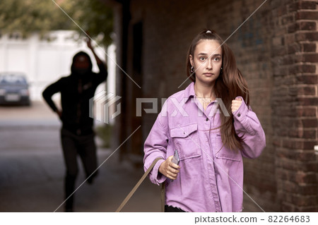 Frightened female is running alone at day time on street. Action. Woman afraid of rapist 82264683
