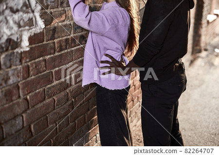 Cropped young woman being assaulted by african man in dark street alley 82264707