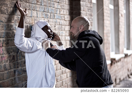 thief holding gun ,Outlaw bad man hold a gun pointing the target at afro guy 82265093
