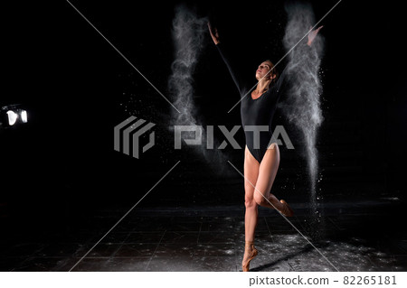 Artistic dance pose using powder or dust. Good-looking expressive ballet dancer in dust 82265181