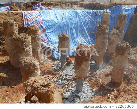 PENANG, MALAYSIA -SEPTEMBER 2, 2021: The process of cutting piles after the completion of building foundation piling work. This work needs to be done before the construction of the cap pile is proceed PENANG, MALAYSIA -SEPTEMBER 2, 2021: The process of cutting piles after the completion of building foundation piling work. This work needs to be done before the construction of the cap pile is proceed 82265366