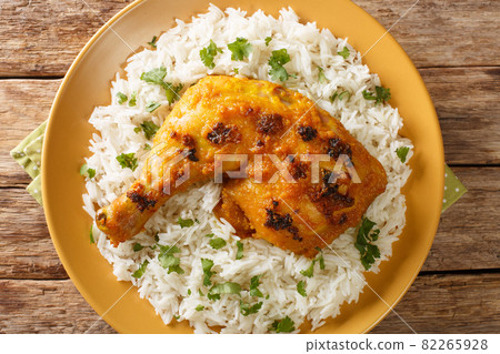 Ayam Percik a Malaysian grilled chicken marinated in flavorful spices served with rice close up in the plate. Horizontal top view 82265928
