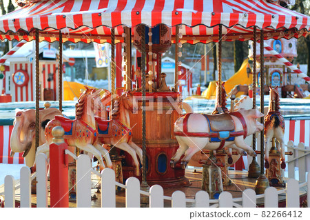 Horses carousel at the amusement entertainment park. Colorful carousel with horses, amusement park element. Children s entertainment, merry-go-round, f 82266412