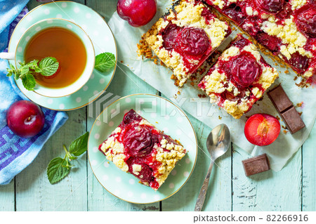 Sweet pie, tart with chocolate and fresh plum. Delicious cake with plum on kitchen table. Top view flat lay. Free space for your text. Sweet pie, tart with chocolate and fresh plum. Delicious cake with plum on kitchen table. Top view flat lay. Free space for your text. 82266916