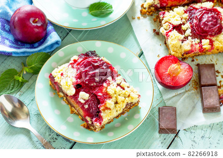 Sweet pie, tart with chocolate and fresh plum. Delicious cake with plum on kitchen table. Sweet pie, tart with chocolate and fresh plum. Delicious cake with plum on kitchen table. 82266918