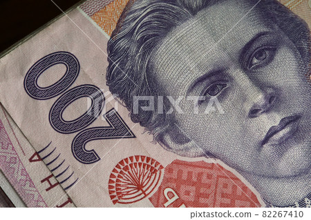 Portrait of Lesya Ukrainka in 200 hryvnia banknotes. Ukrainian paper bank notes, close-up. 82267410