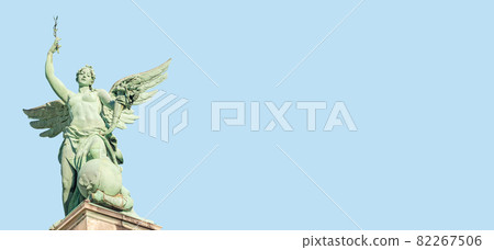 Banner with top roof statue of sensual Renaissance Era angel with wings in front of blue sky with copy space in Vienna, Austria, with blue sky solid background. 82267506