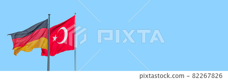 Banner with national black red yellow flag of Germany and red Turkish flag with white crescent moon and star at blue sky background with copy space. Concept of nationality, citizenship and patriotism. Banner with national black red yellow flag of Germany and red Turkish flag with white crescent moon and star at blue sky background with copy space. Concept of nationality, citizenship and patriotism. 82267826