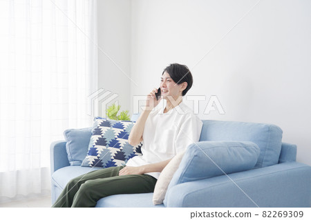 使用智能手機的男士的起居室 82269309