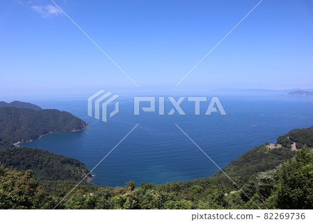 Mountains of green trees, roads, peninsulas, blue seas, ships, hazy peninsulas in the distance, blue skies, and hazy seas and skies near the horizon. Mountains of green trees, roads, peninsulas, blue seas, ships, hazy peninsulas in the distance, blue skies, and hazy seas and skies near the horizon. 82269736