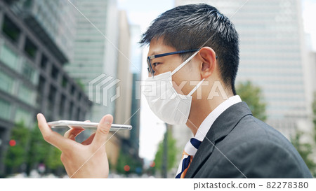 一個戴著面具並撥打揚聲器電話的男人 82278380