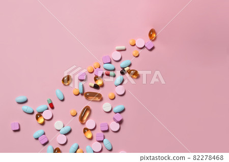 Pharmaceutical tablets and capsules on pink background. Medical health care concept. Pharmaceutical tablets and capsules on pink background. Medical health care concept. 82278468