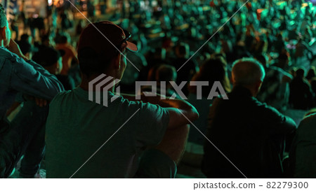 Man watching football in a public place at night Man watching football in a public place at night 82279300