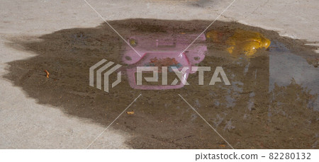 Pink children's car in the park , reflected in a puddle after the rain Pink children's car in the park , reflected in a puddle after the rain 82280132