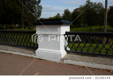 Wrought-iron fence on the bridge in the park on an autumn day 82280144