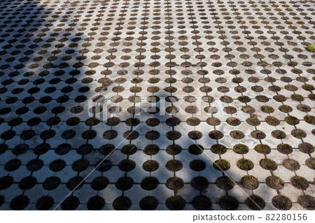 Geometric gray concrete tile with eco-parking cells With a hole for grass. Top view, paving stones for grass, block tiles made of concrete in the form of connected circles 82280156