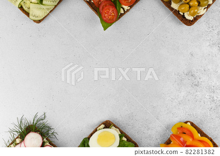 Top view frame open faced vegetarian sandwiches on stone background. Top view frame open faced vegetarian sandwiches on stone background. 82281382