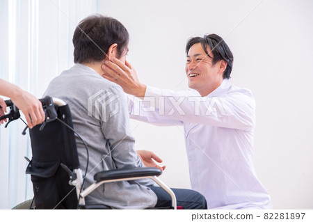 A doctor looking at the eyes and a patient in a wheelchair (ophthalmologist) 82281897