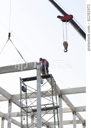 precast concrete beam intralled at construction site by mobile crane 82282972