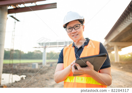 Asian worker using digital tablet at construction site 82284317
