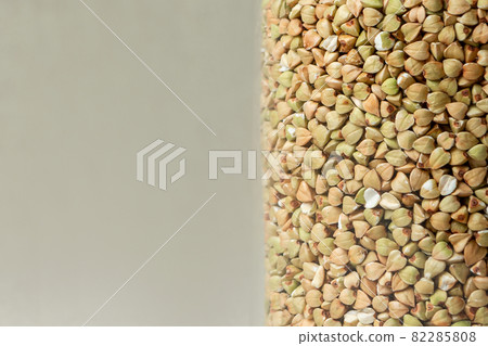 green buckwheat grains close-up on beige background colored 82285808