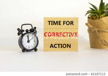 Time for corrective action symbol. Blocks with words time for corrective action. Black alarm clock, house plant. Beautiful white background. Copy space. Business, time for corrective action concept. 82287113