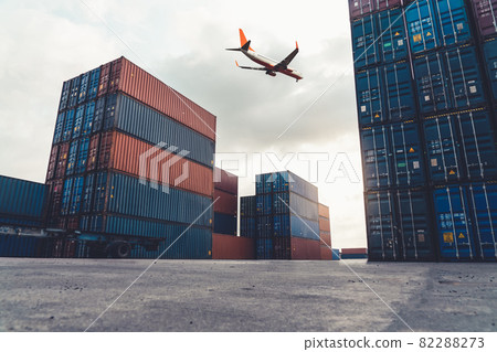 Freight airplane flying above overseas shipping container 82288273