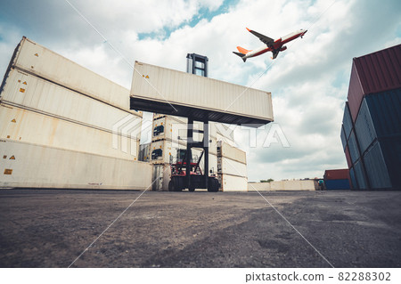 Cargo container for overseas shipping in shipyard with airplane in the sky . Cargo container for overseas shipping in shipyard with airplane in the sky . 82288302