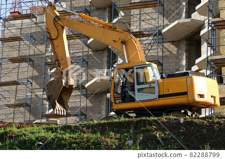 Heavy buildind excavator in front of building site , Moscow, Russia Heavy buildind excavator in front of building site , Moscow, Russia 82288799