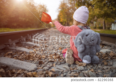 child playing on an abandoned railway line catching the last rays of the sun that day. child playing on an abandoned railway line catching the last rays of the sun that day. 82290168