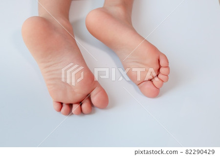 The soles of the left and right feet of the infant are stored on a white background. 82290429