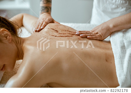 confident female specialist is doing relaxing body massage for beautyful slim caucasian lady at minimalistic spa salon 82292178