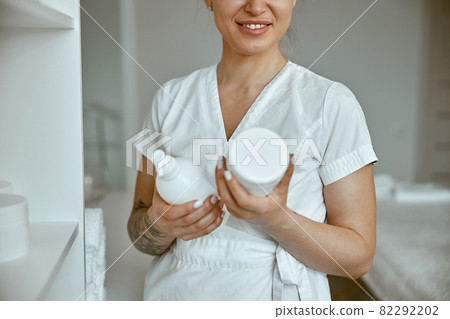 beautiful happy caucasian female masseur is posing in white minimalistic modern treatment salon beautiful happy caucasian female masseur is posing in white minimalistic modern treatment salon 82292202