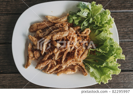 Thai crispy fish served in white dish decorated with vegetable. 82295997