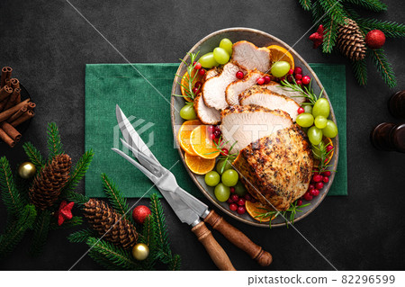 Christmas turkey dinner. Christmas turkey with decorations on black background, top view. 82296599