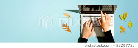 Autumn leaves with person using a laptop computer 82297753