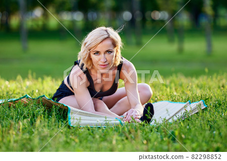 Elegant european woman trains yoga outdoors at summer day. Elegant european woman trains yoga outdoors at summer day. 82298852