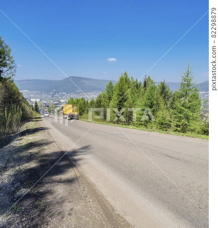 Highway in the Siberian taiga at the entrance to the city of Ust-Kut. Highway in the Siberian taiga at the entrance to the city of Ust-Kut. 82298879