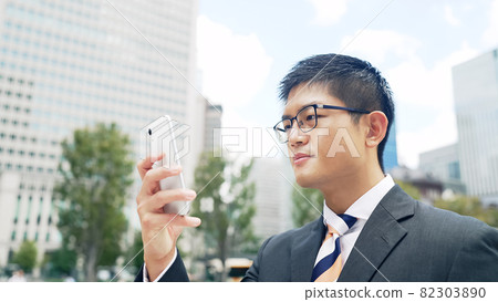 看有城市的一個商人智能手機在背景中 82303890