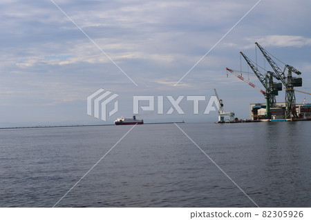 清晨多雲的天空,大海,起重機,倉庫,碼頭,燈塔,還有一個風景,有渡輪和進入港口後看起來更大的朦朧山 清晨多雲的天空,大海,起重機,倉庫,碼頭,燈塔,還有一個風景,有渡輪和進入港口後看起來更大的朦朧山 82305926