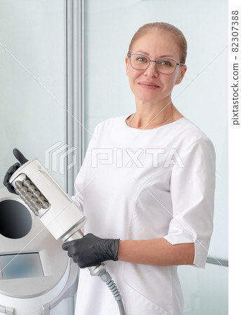 cosmetologist standing in rubber gloves doing endospheres therapy cosmetologist standing in rubber gloves doing endospheres therapy 82307388