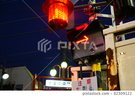 道口障礙物下降的鐵路道口,警報響起,然後火車立即通過。 道口障礙物下降的鐵路道口,警報響起,然後火車立即通過。 82309122