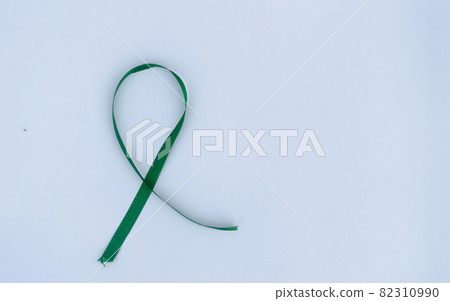 Green Awareness Ribbon on white background. Table top view. Health care and medical. Copy space for text. Green Awareness Ribbon on white background. Table top view. Health care and medical. Copy space for text. 82310990