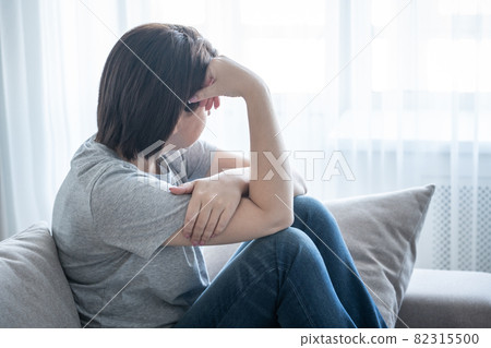 Sad girl sits on the sofa at home, problem concept Sad girl sits on the sofa at home, problem concept 82315500