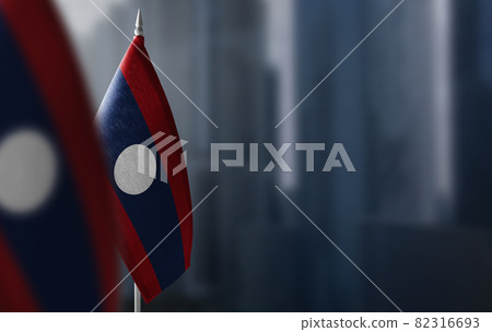 Small flags of Laos on a blurry background of the city Small flags of Laos on a blurry background of the city 82316693