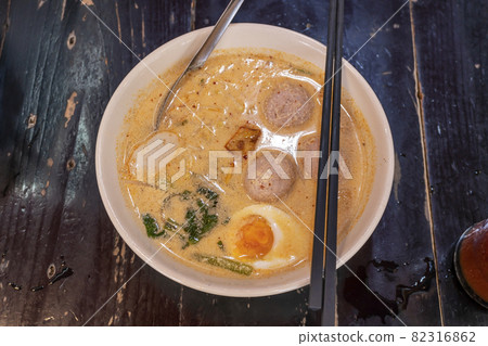 Pork noodle tom yum with egg on blurred wooden Pork noodle tom yum with egg on blurred wooden 82316862
