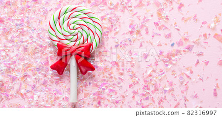 Sweet Lollipop with red bow on pink Background with shiny glitter with copy space 82316997