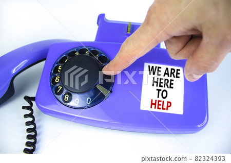 We are here to help symbol. Old blue rotary dial telephone. Words 'we are here to help'. Beautiful white background. Business, help is here and support concept, copy space. Businessman hand. 82324393