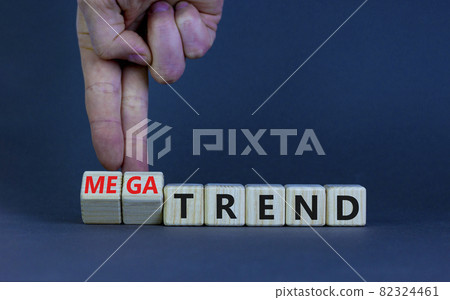 Trend or megatrend symbol. Businessman turns wooden cubes and changes words trend to megatrend. Beautiful grey table, grey background, copy space. Business, trend or megatrend concept. Trend or megatrend symbol. Businessman turns wooden cubes and changes words trend to megatrend. Beautiful grey table, grey background, copy space. Business, trend or megatrend concept. 82324461